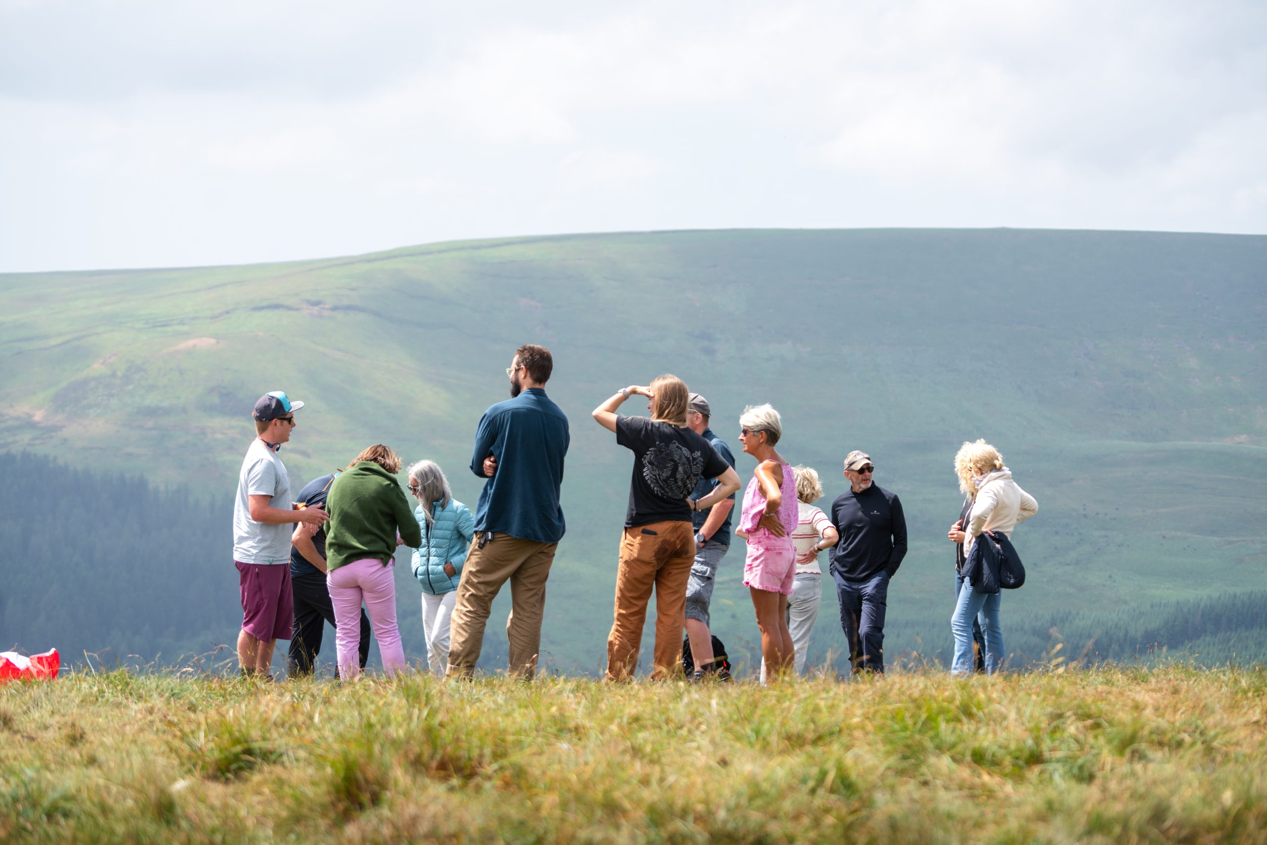 Visitors watching paragliding activities on the mountains above Crickhowell.