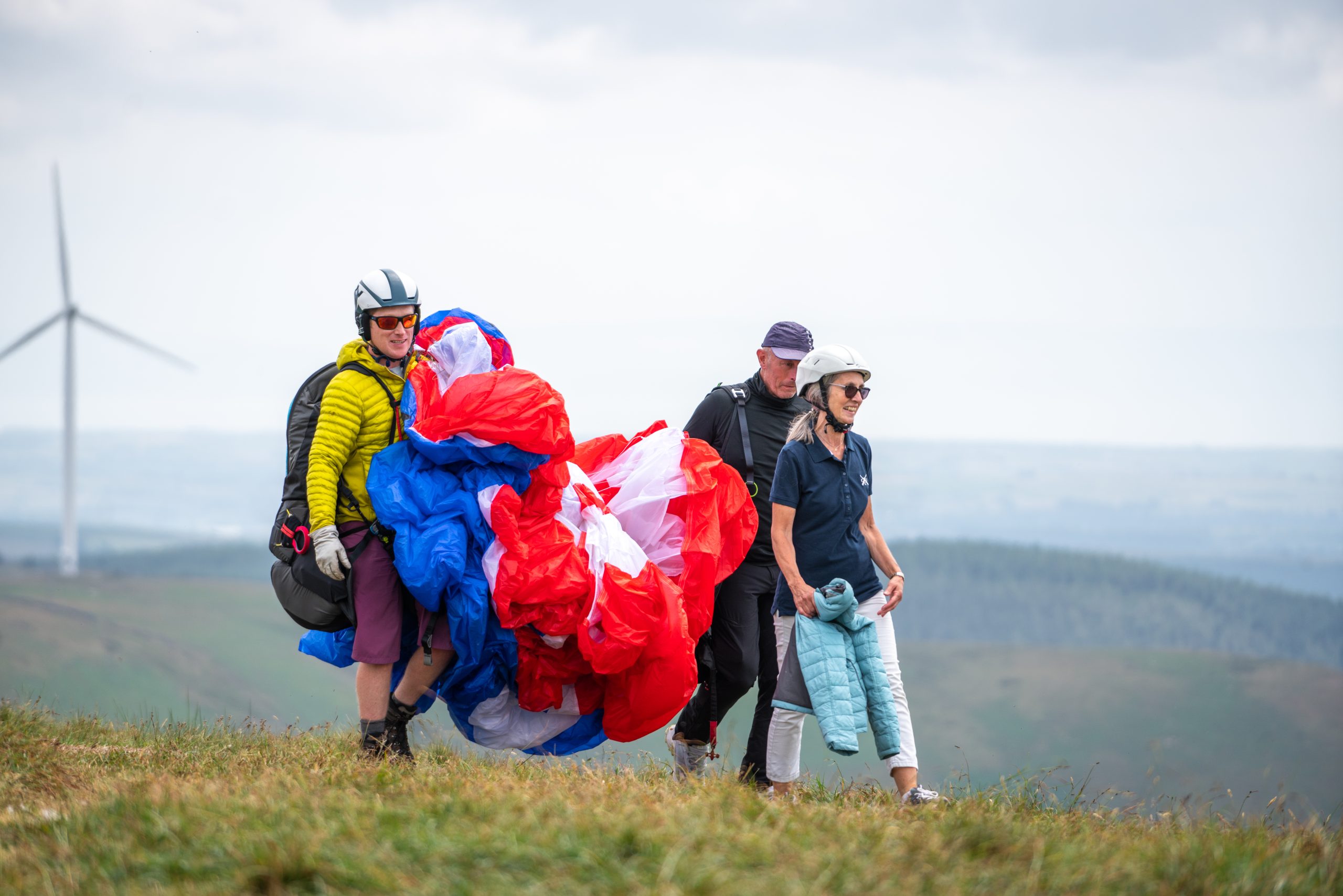Visitors walking back after a tandem paragliding experience in Bannau Brycheiniog.
