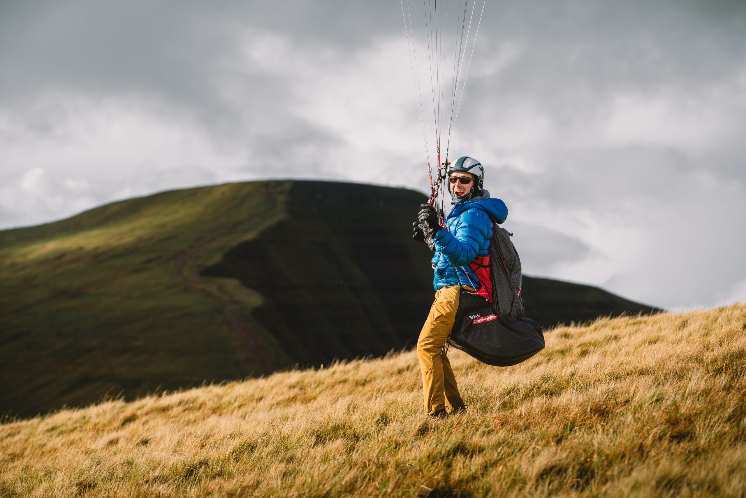 Paraglider flying above the dramatic mountain landscape of Bannau Brycheiniog.