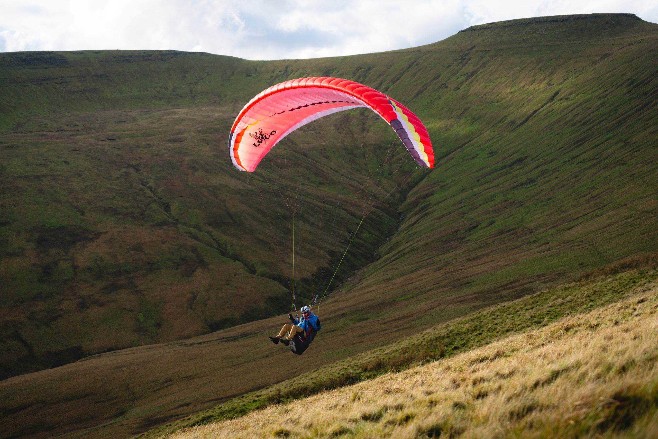 Solo paraglider flying above the mountains of Bannau Brycheiniog near Crickhowell.