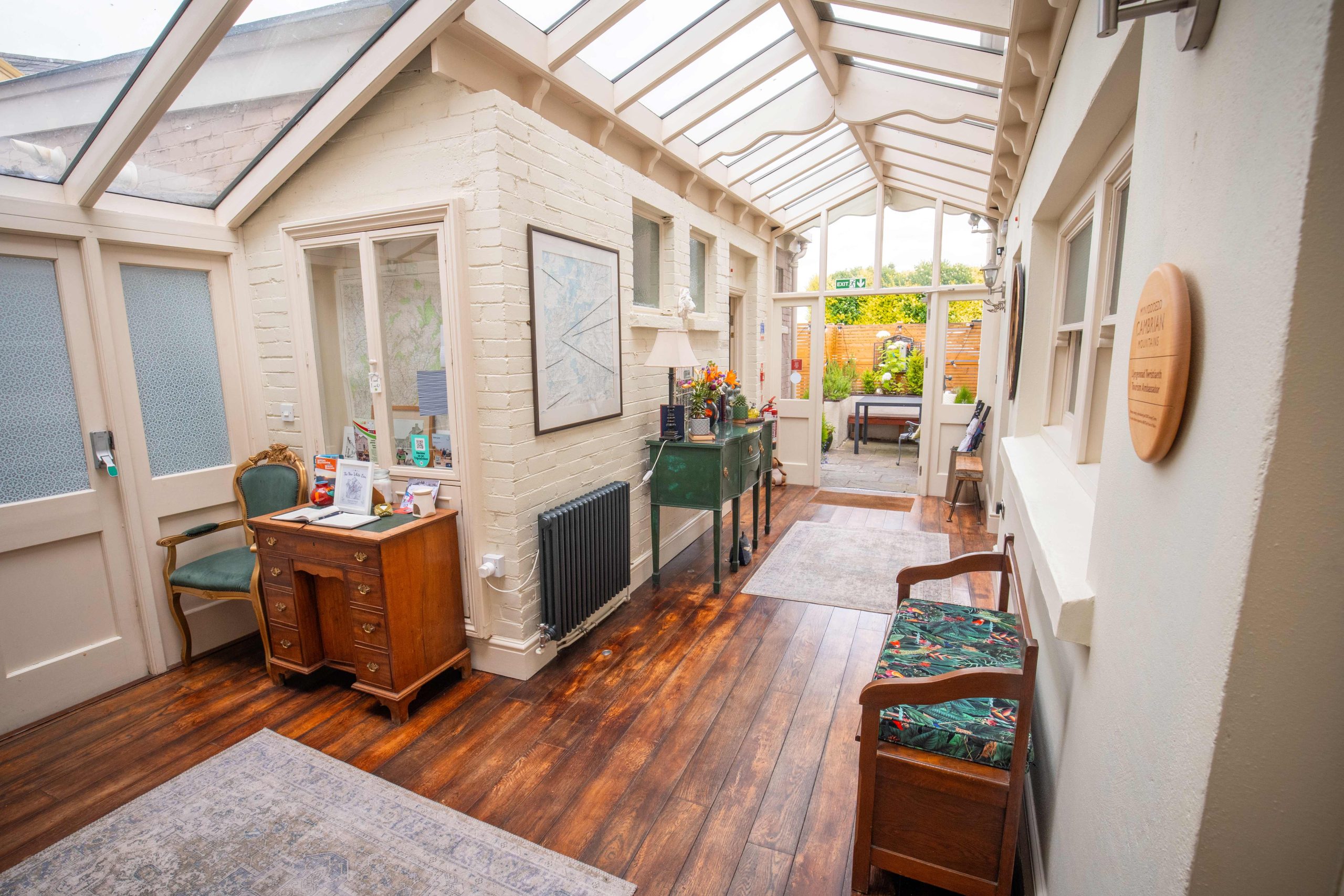 The entrance hallway to thhe Bed & Breakfast, a conservatory style walk way with seated spaces to get out of the muddy gear.