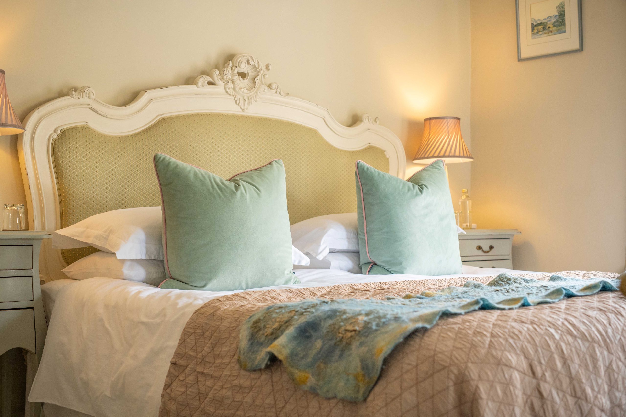 A double room in light colours, big fluffed up pillows and a bed made ready to fall into