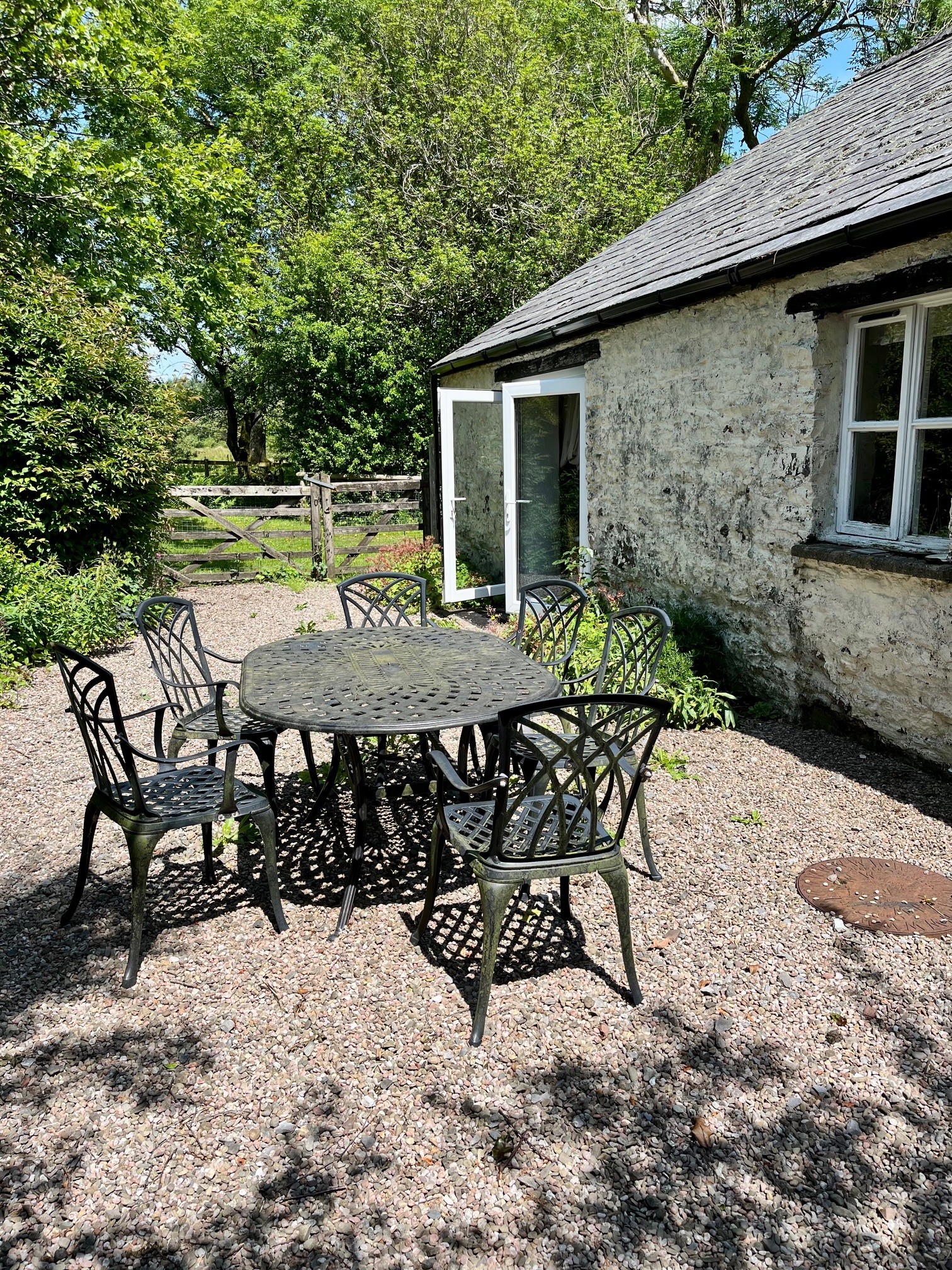 OUtdoor seated area beside french doors that open from the cottage oput