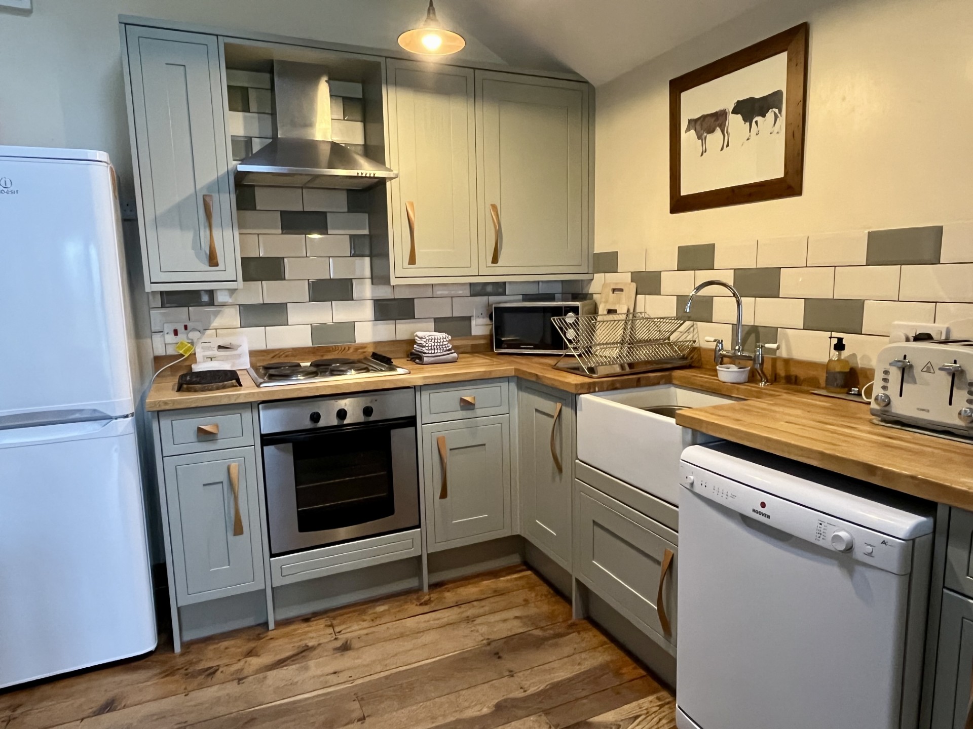 the kitche area at Bryniau Pell cottage with white goods such as the dishwasher
