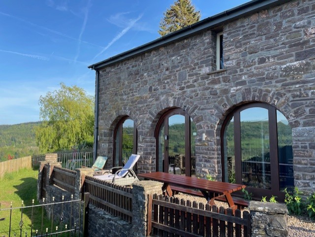 a side view of the houes with outdoor seated area and loungers.