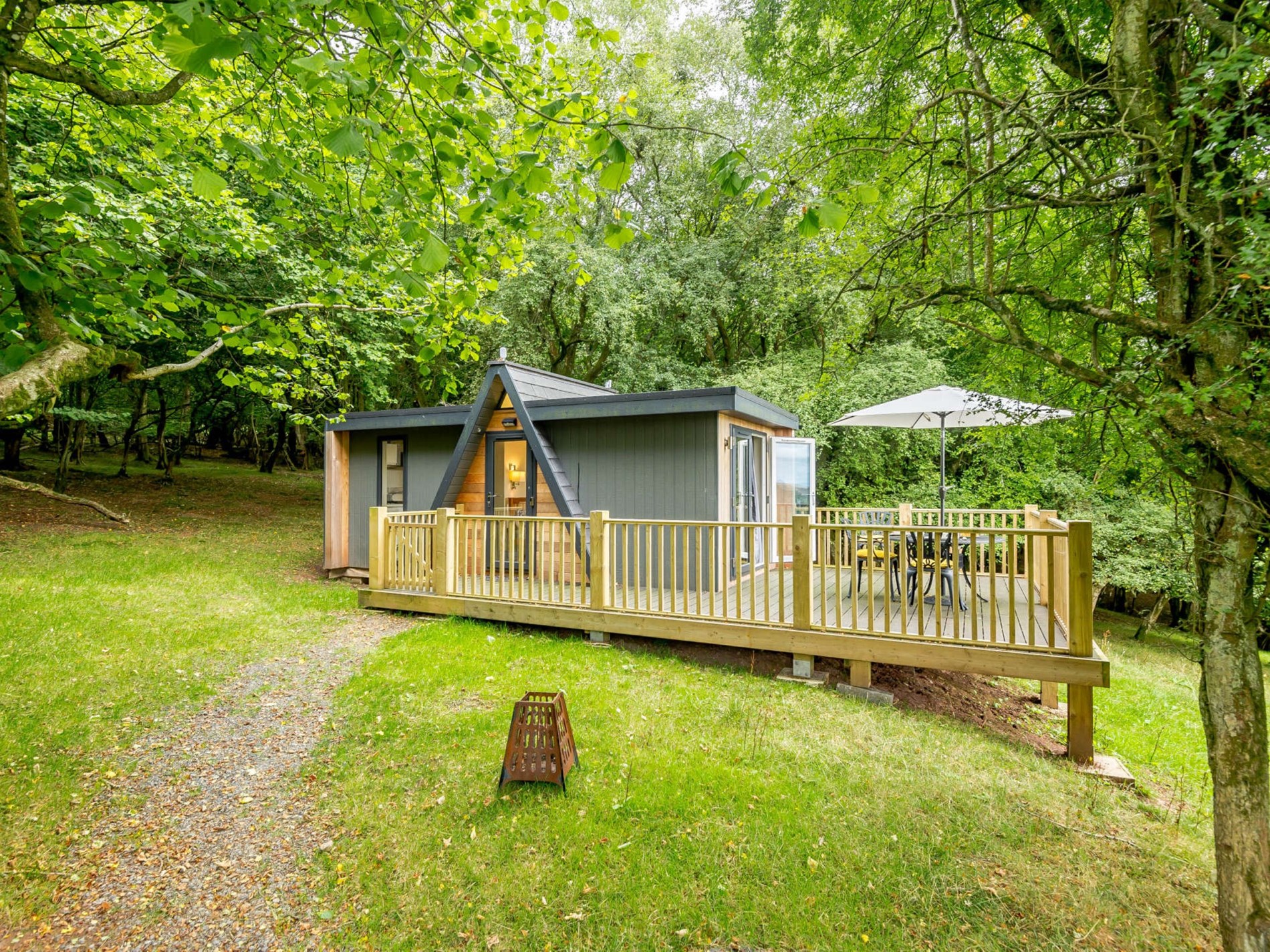 Modern forest lodge with outdoor decking in woodland near Bannau Brycheiniog (Brecon Beacons) National Park
