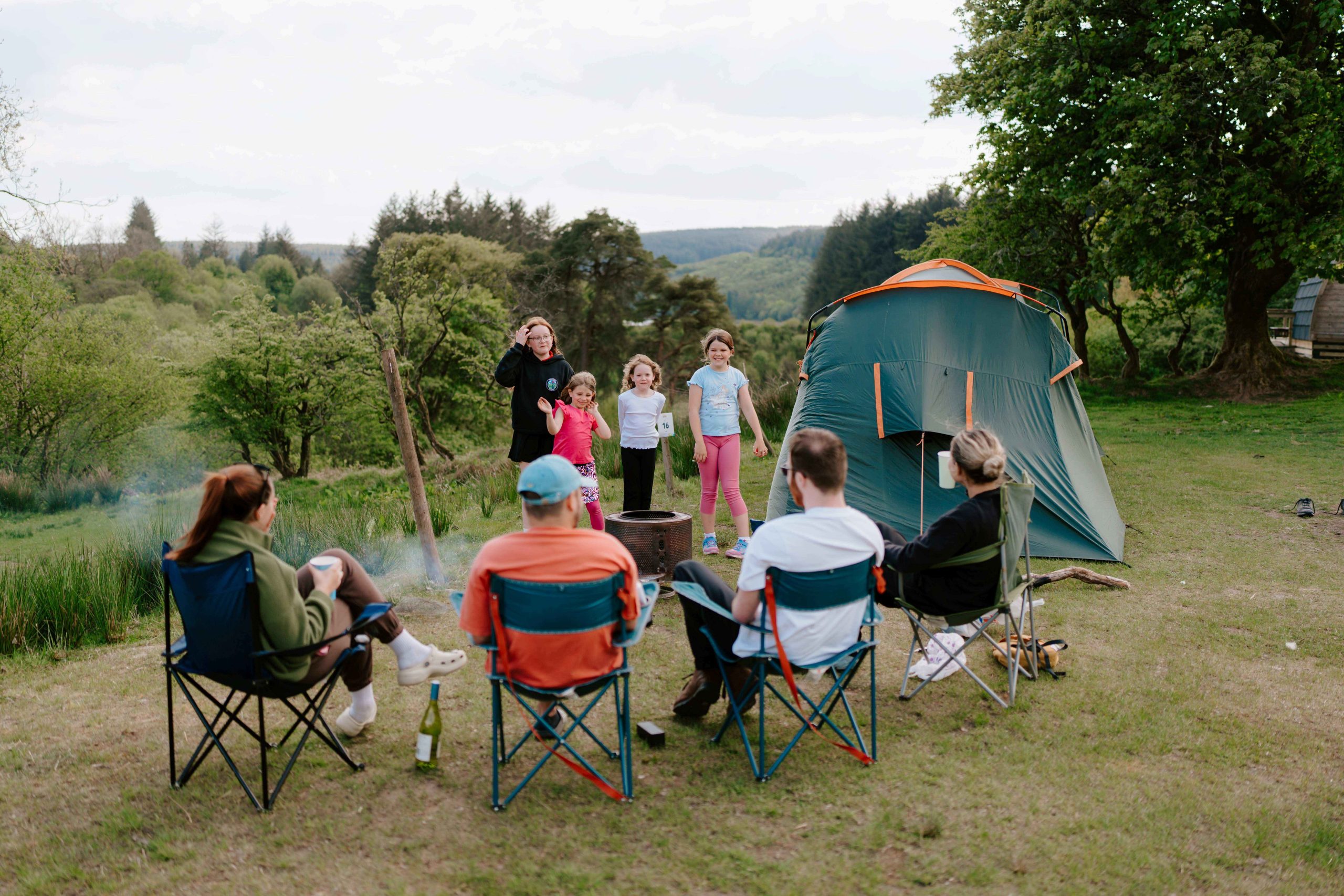 a group sat outside their tent enjoying and vening together