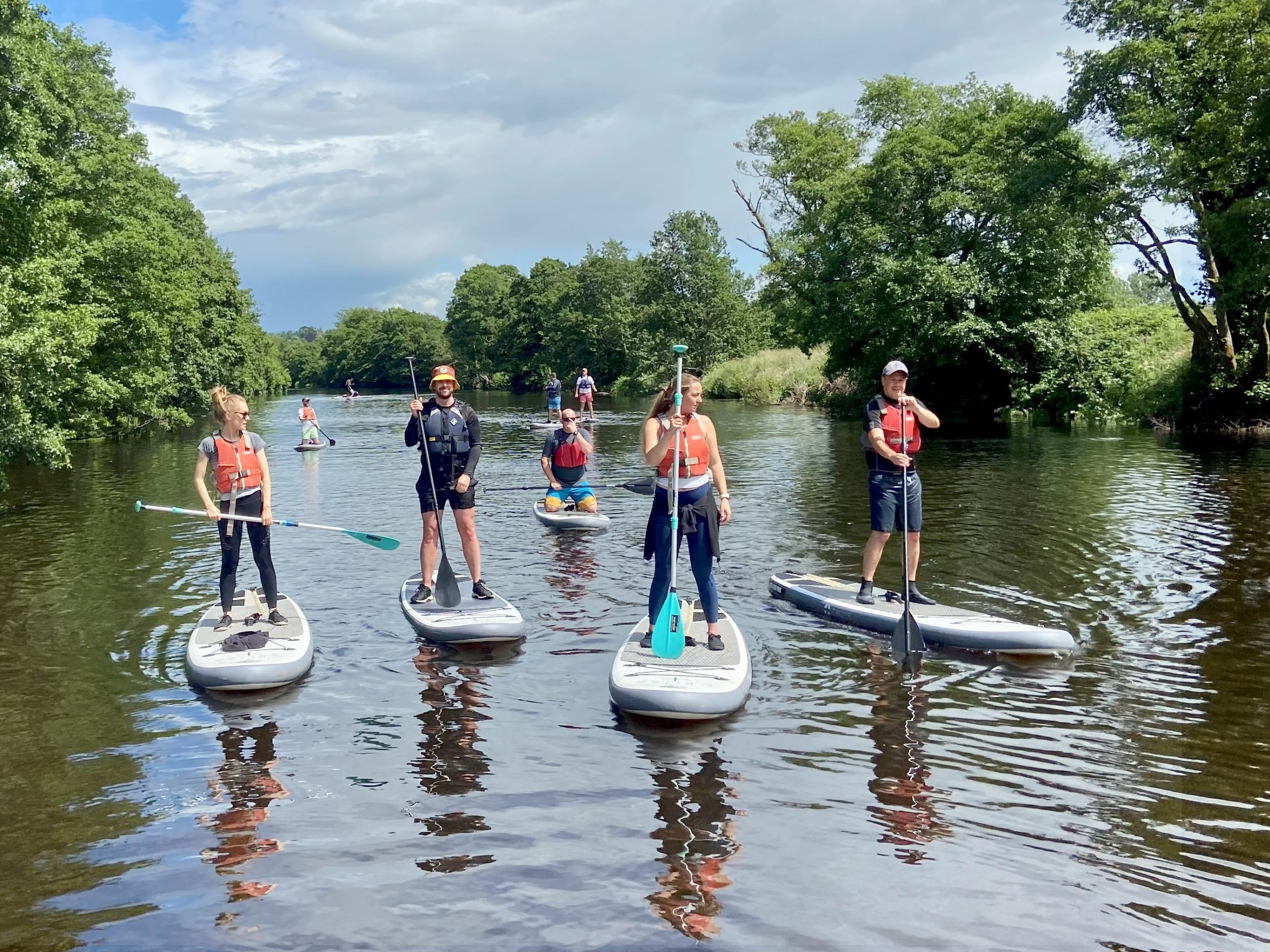 a group on stand up paddle boards on teh River Wye