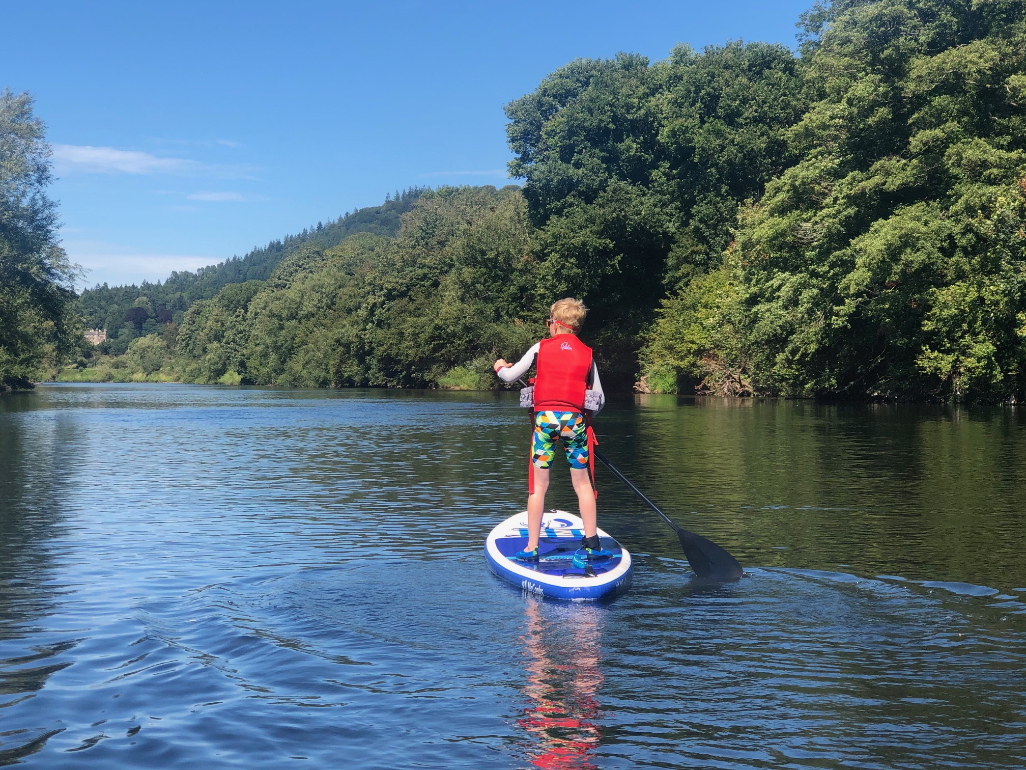 Stand-up paddle boarding on calm water in Bannau Brycheiniog.