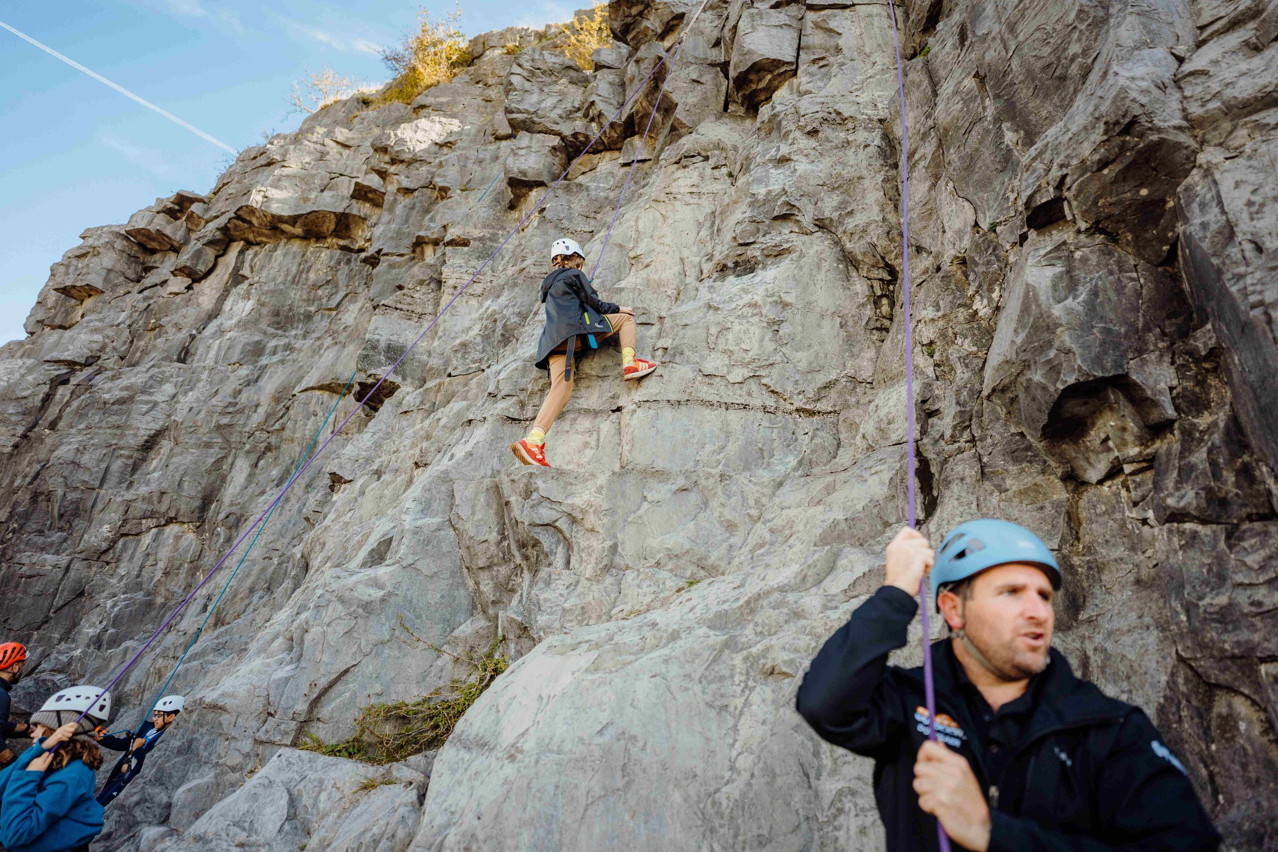 Instructed climbing session with a young girl top roping on a cliff face