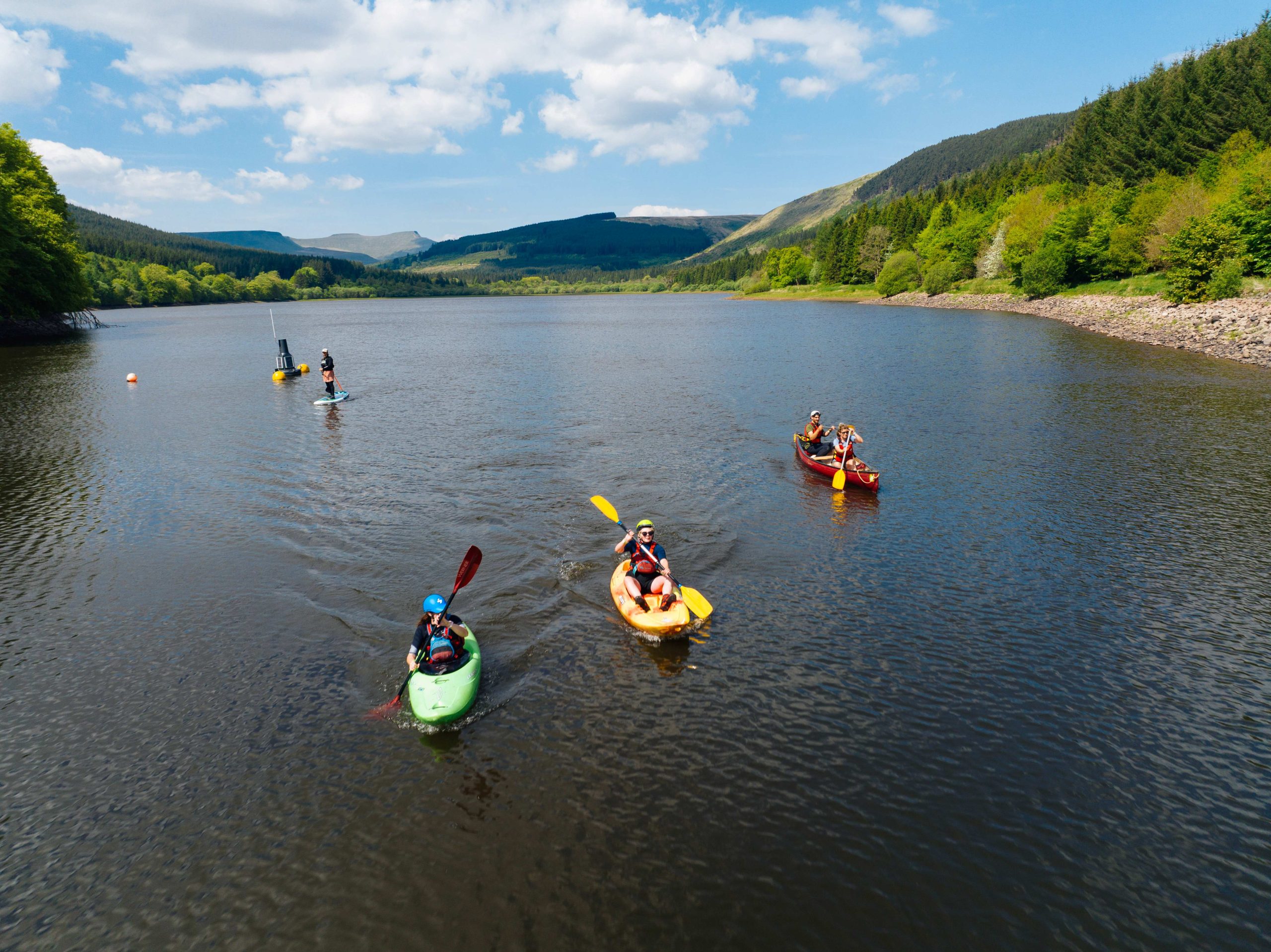 a group of five people enjoying the water and the views under instruction on kayaks.