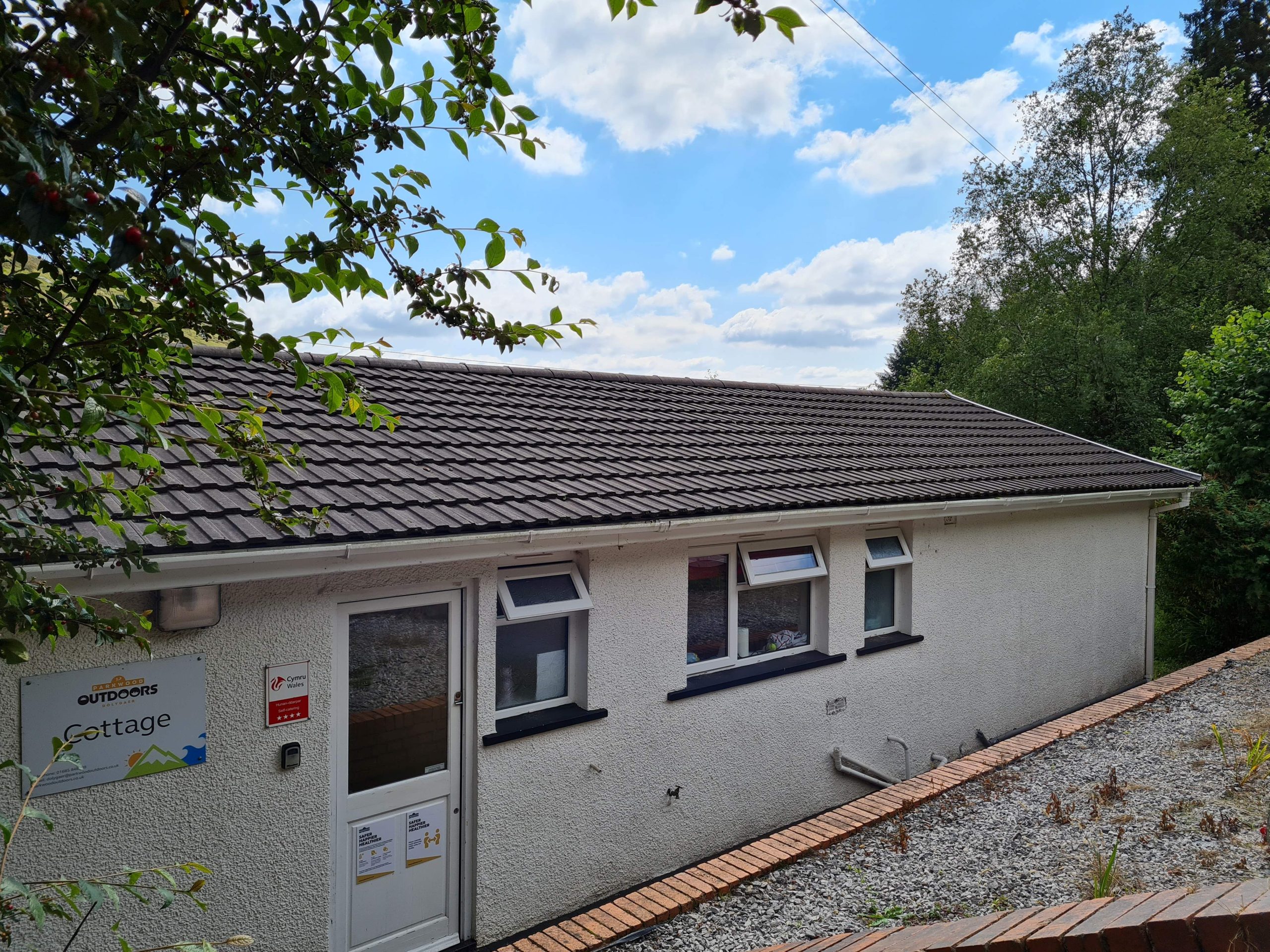 a white building with an entrance into the cottage space for self catering