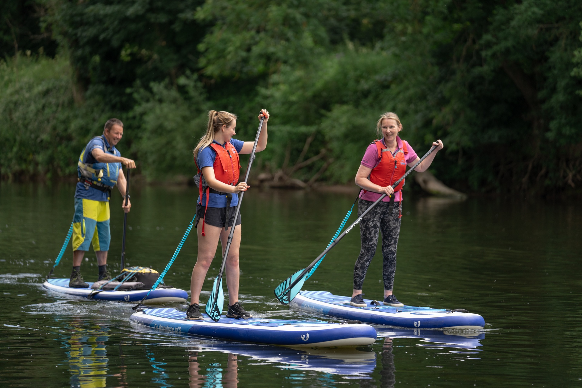 Stand-up paddle boarding on calm water in Bannau Brycheiniog.