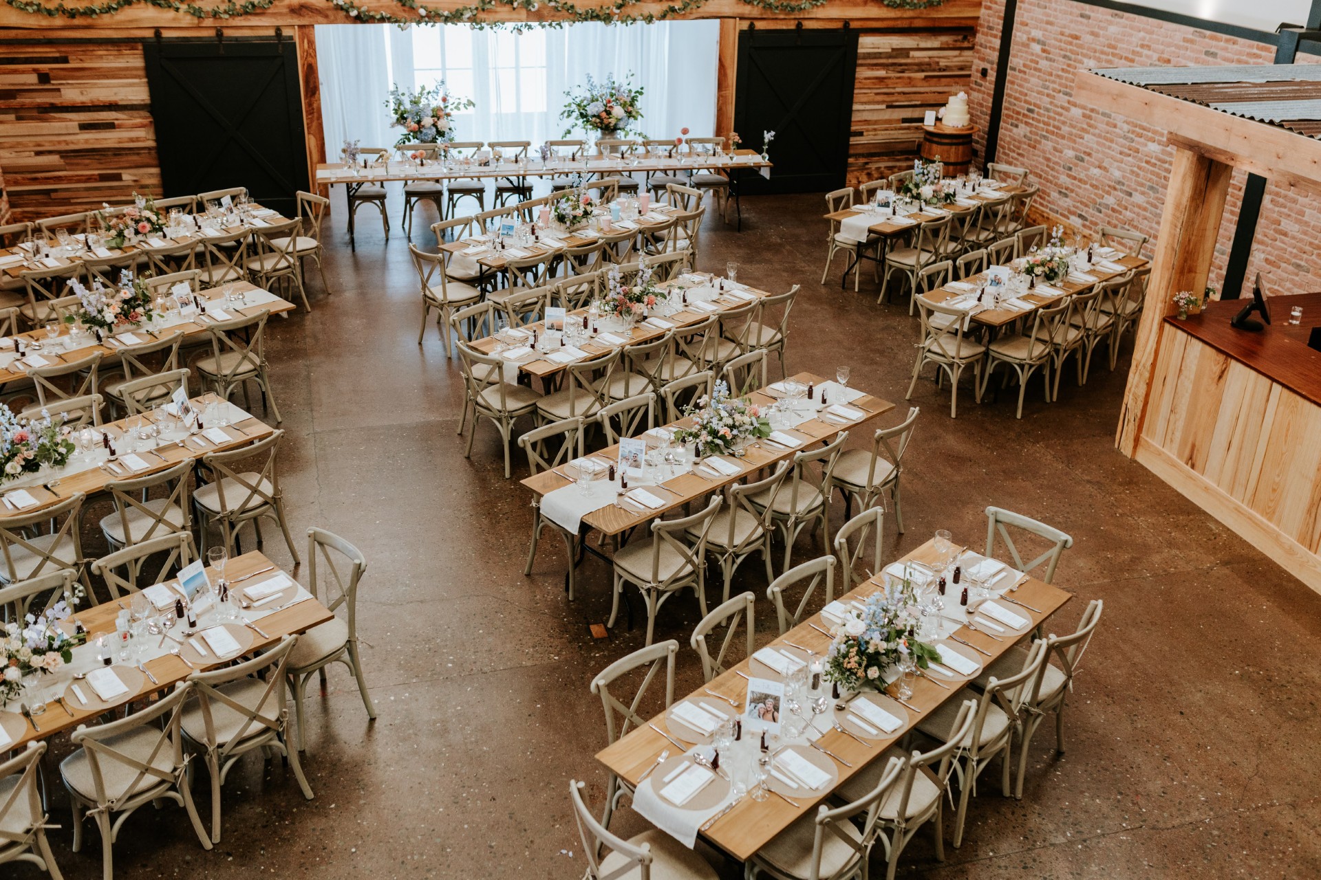 Barn wedding reception setup at Barn at Brynich in Bannau Brycheiniog (Brecon Beacons) National Park, featuring rustic styling, long banquet tables and elegant floral décor.