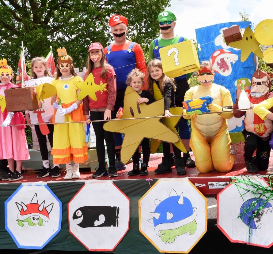 a selection of young people in fancy dress on teh back of a carnival float