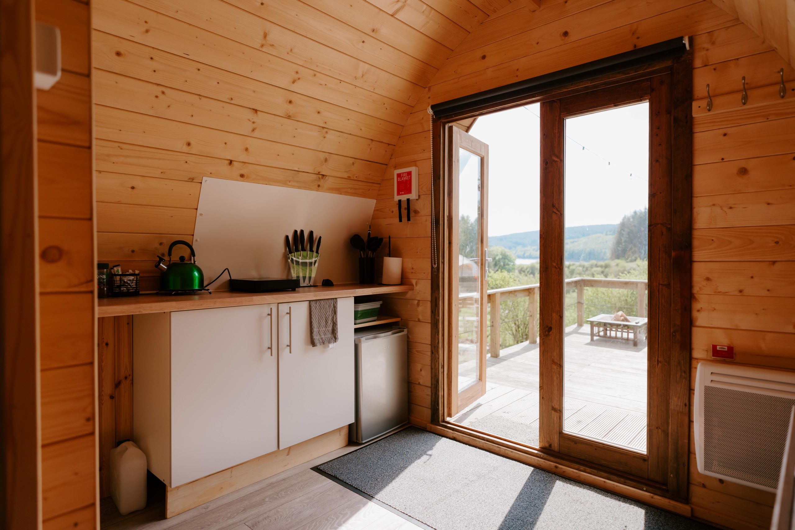 the kitchen area at the front of the pod opening up onto the decking area