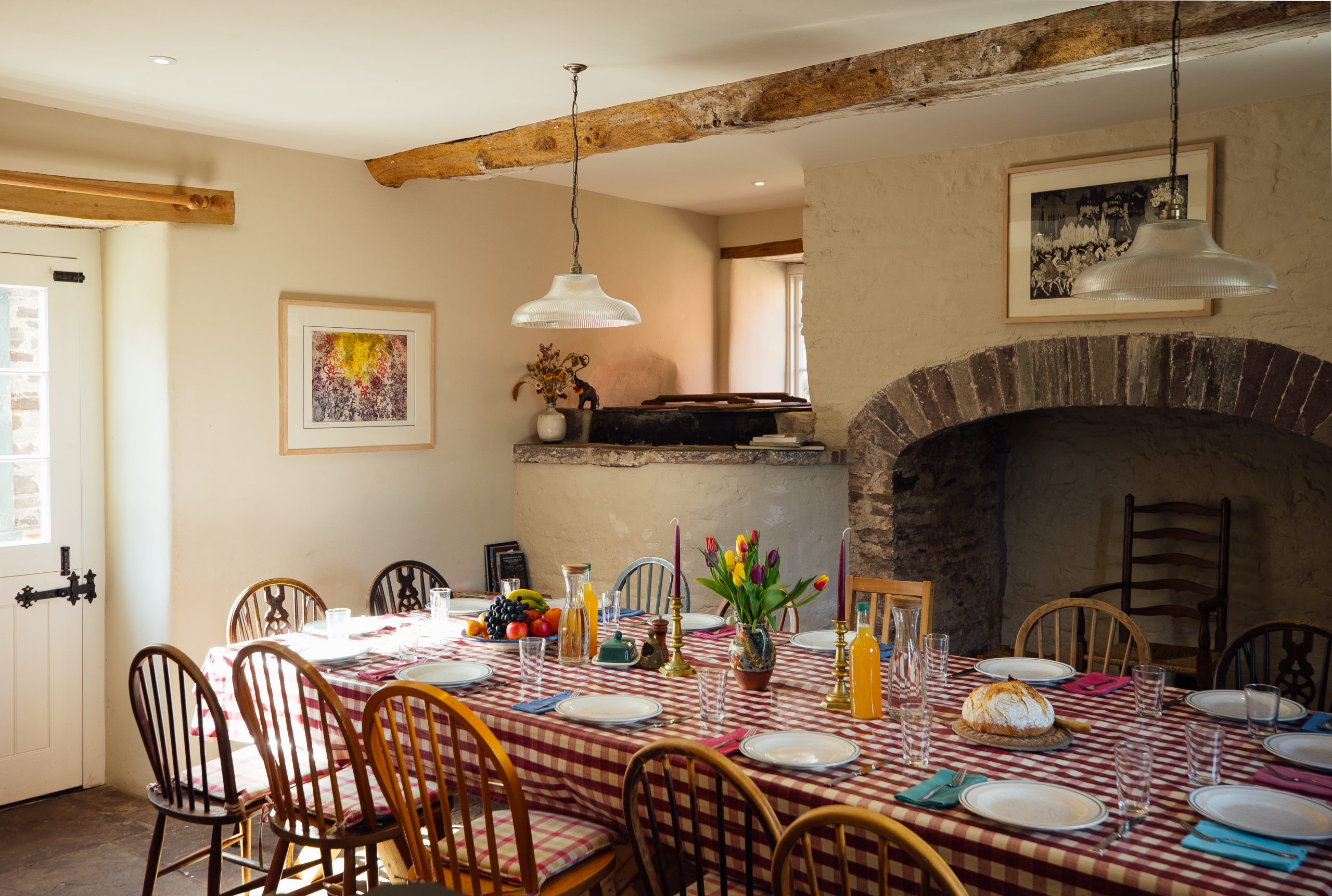 a long dining table set for a family meal in a large open eating area beside the kitchen