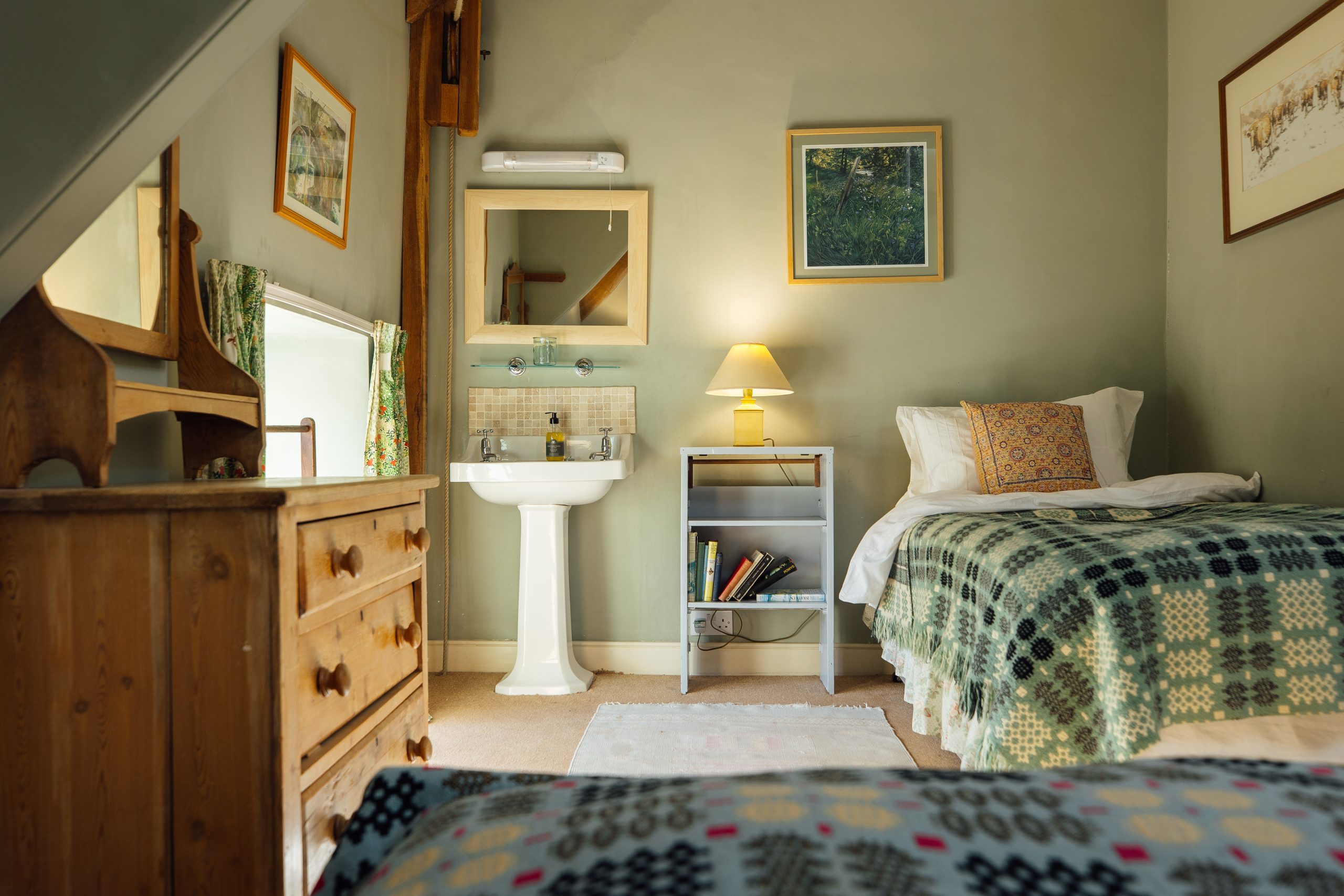 a bedroom with lovely light furnishings and decor. Handbasin the room