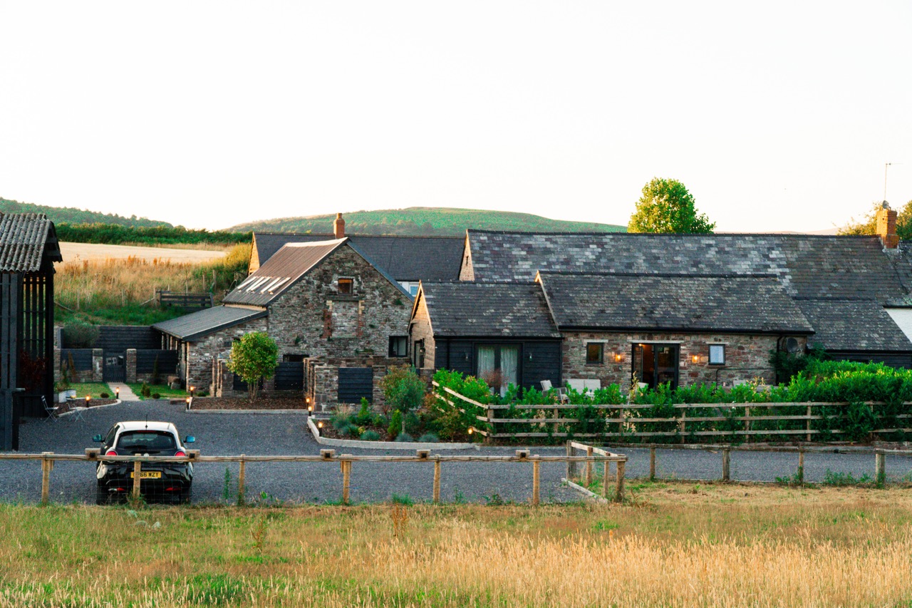 Stone barn cottages at Pwll Court Retreat surrounded by countryside in Bannau Brycheiniog (Brecon Beacons) National Park.
