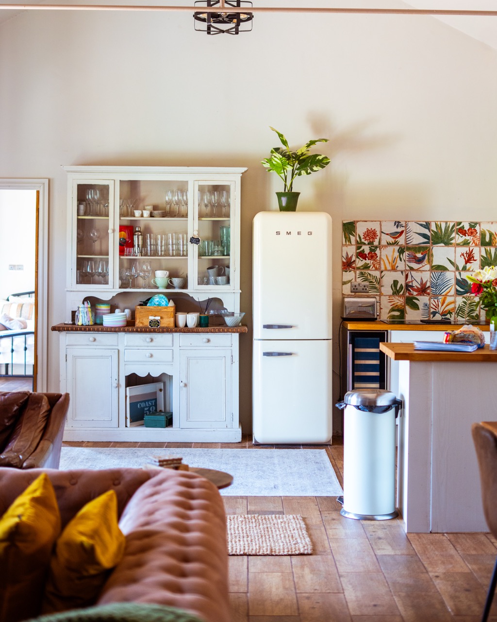 Open-plan kitchen and living area at Pwll Court Retreat with wooden floors, beams and countryside views