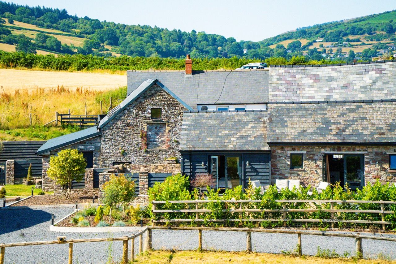 Converted stone barns at Pwll Court Retreat with private gardens and rural views in Bannau Brycheiniog.