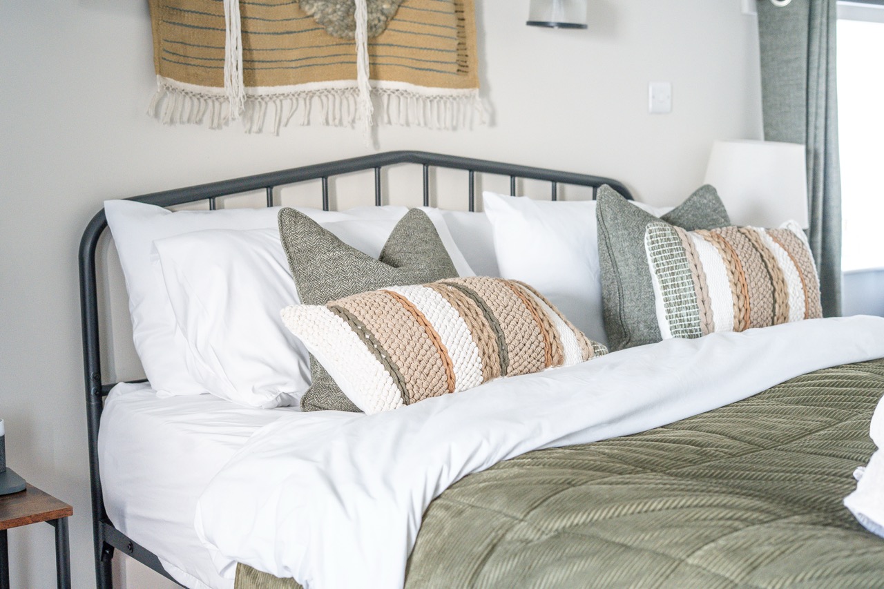 Double bedroom at Pwll Court Retreat with soft furnishings, neutral décor and countryside outlook.