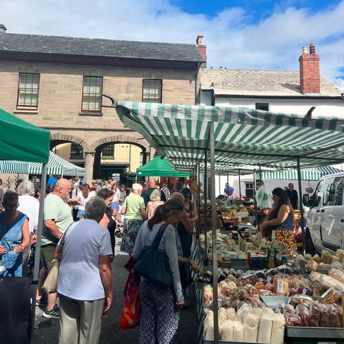 Hay Market on a warm summer day with people around teh stalls, Hay on Wye, Brecon Beacons
