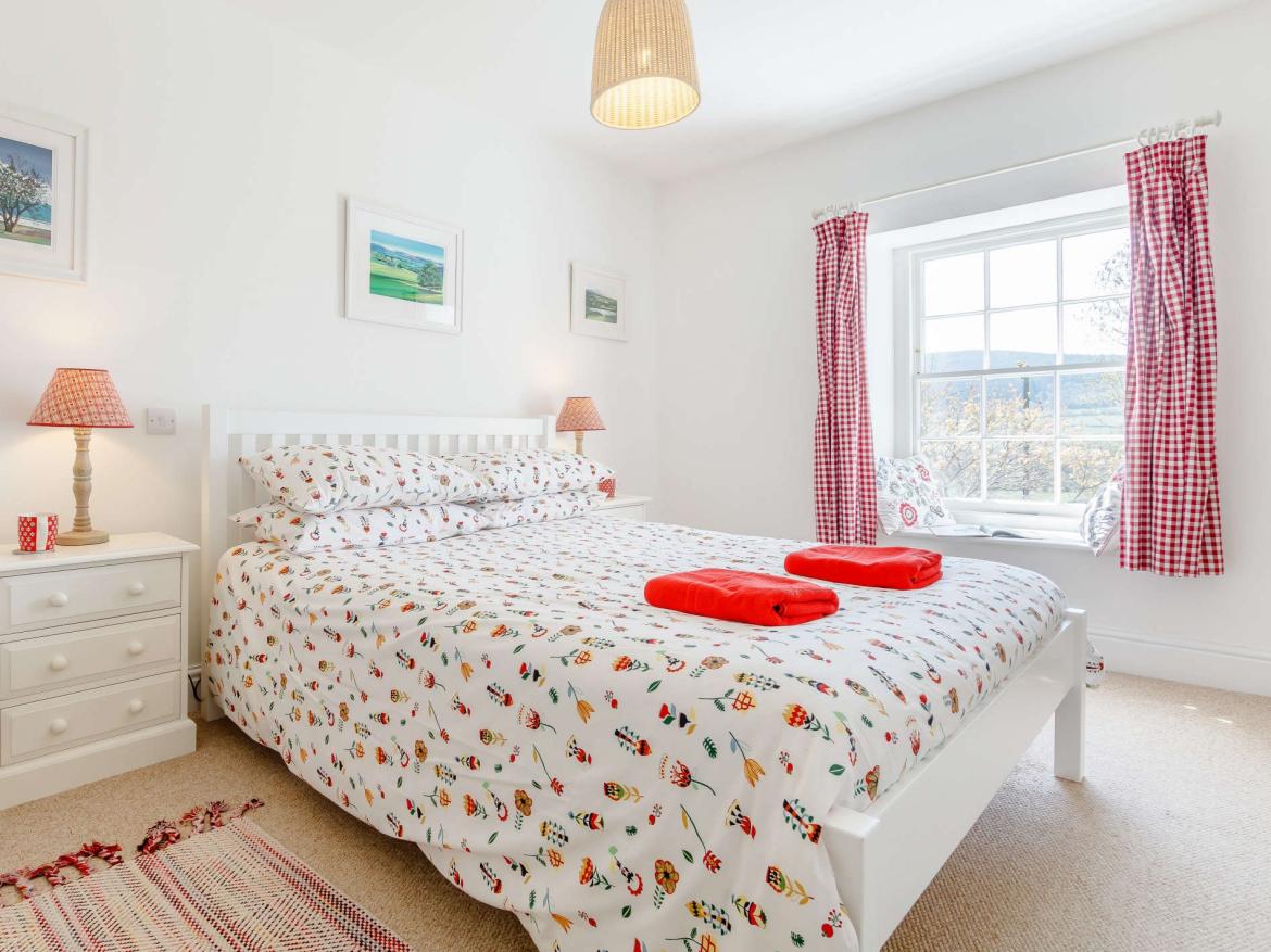Light-filled bedroom at Tower House with countryside views and calm décor.