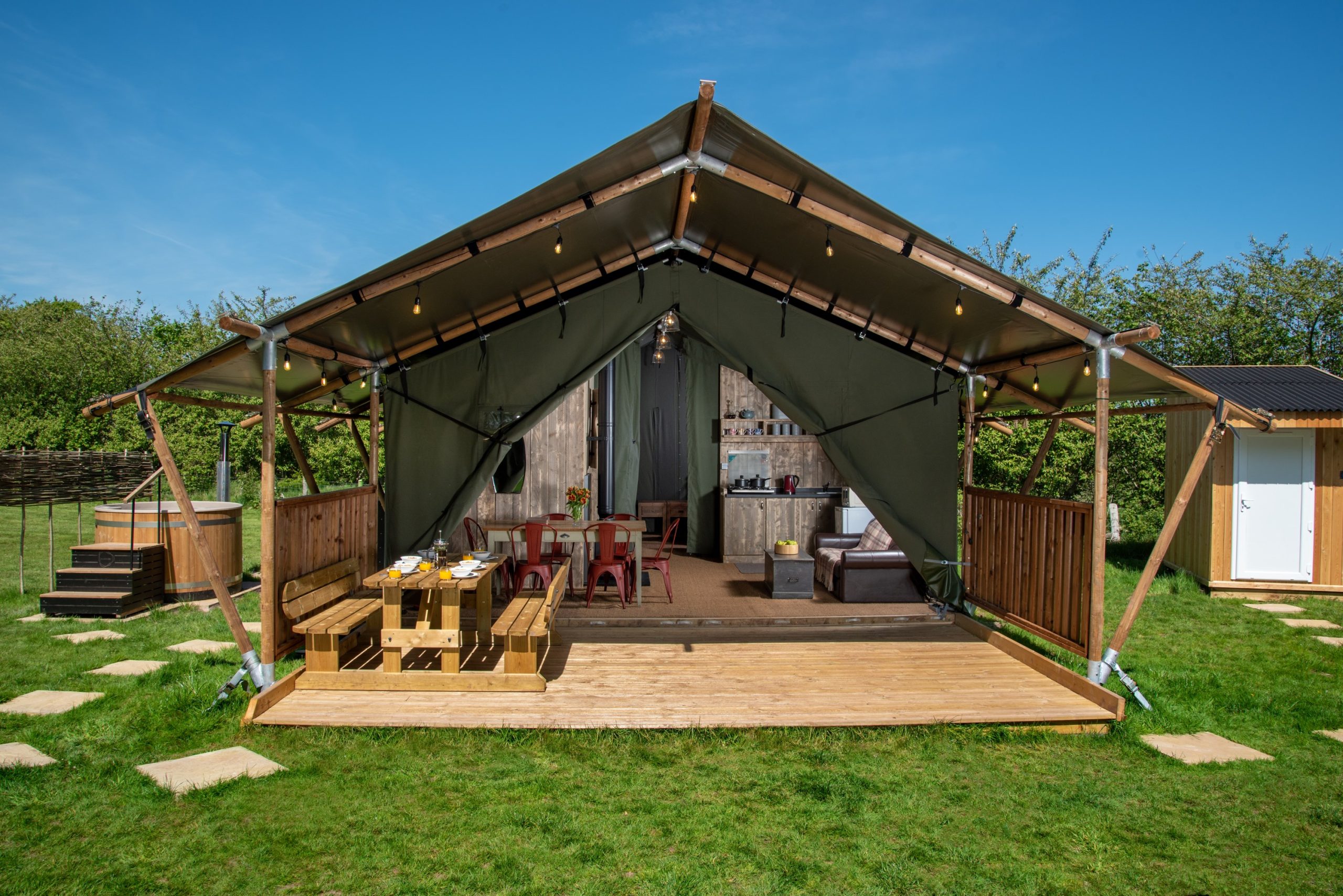 Luxury safari tent with outdoor dining area and wood-fired hot tub in Bannau Brycheiniog (Brecon Beacons) National Park