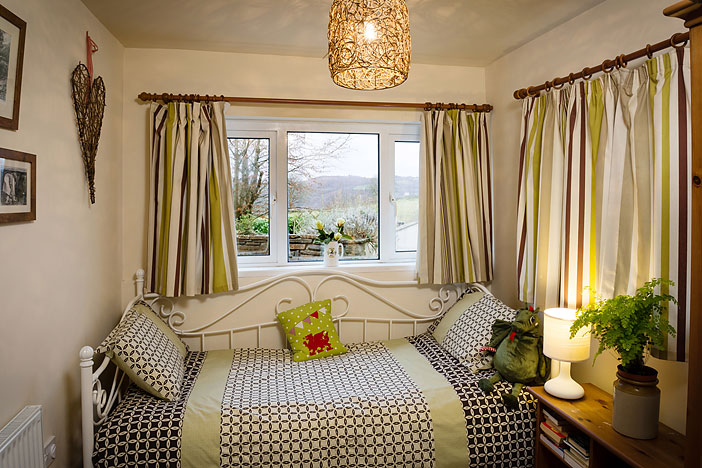 Single bed beside the window in the Farm Cottage ground-floor bedroom at Tan yr Eglwys.