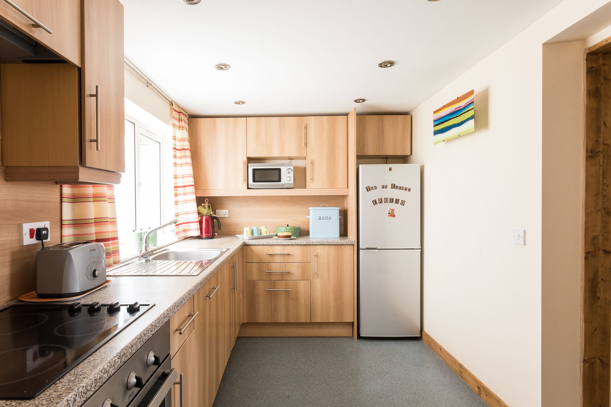 Wooden kitchen cupboards, oven and hob in the Farm Cottage at Tan yr Eglwys.