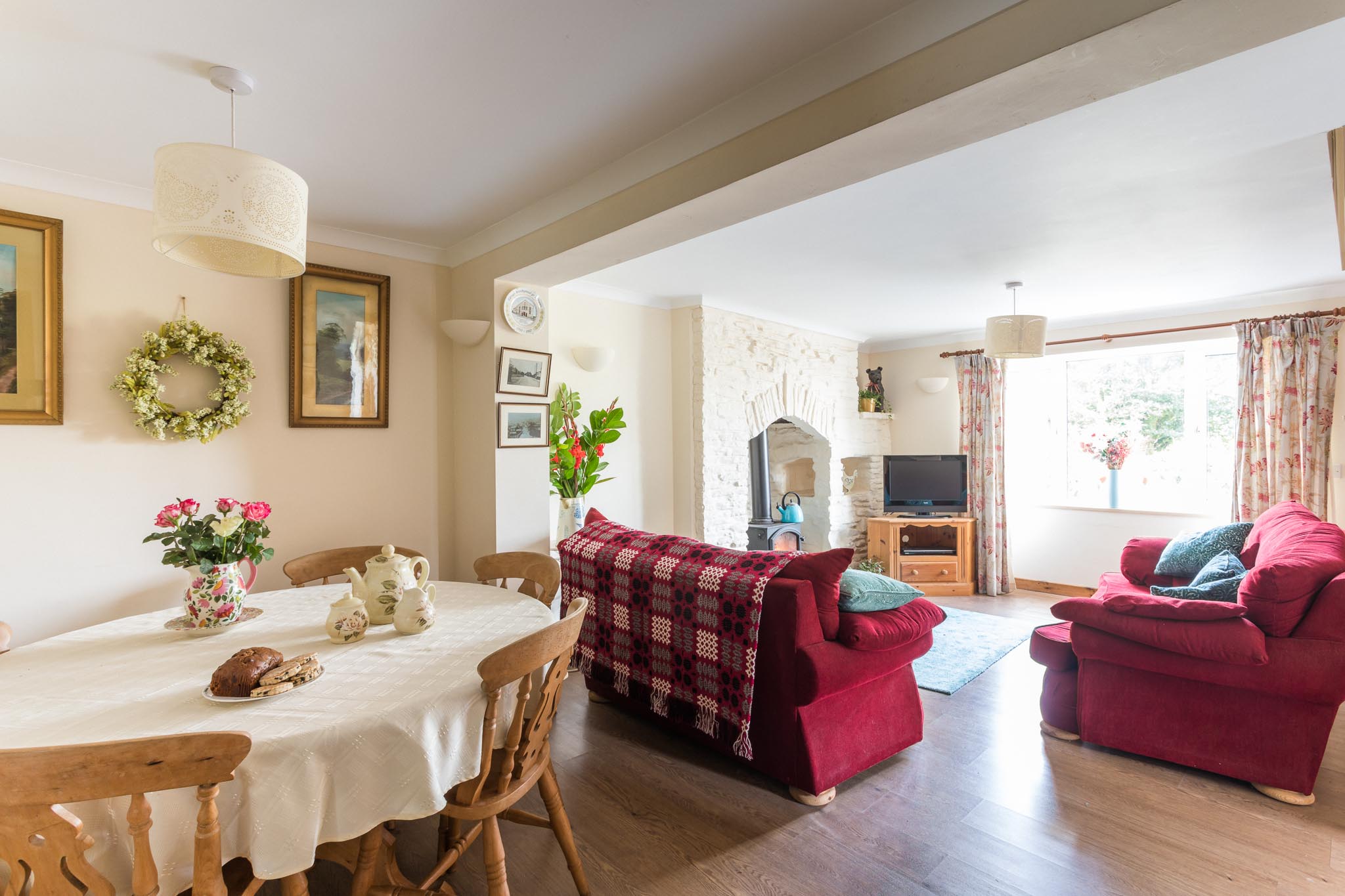 Red seating around the wood-burning stove in the Farm Cottage lounge at Tan yr Eglwys.